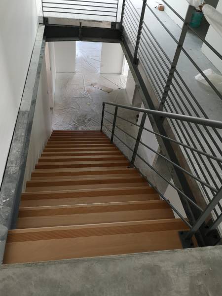 Installation d'un escalier droit avec des marches en bois et d'un garde-corps rampant sécurisant